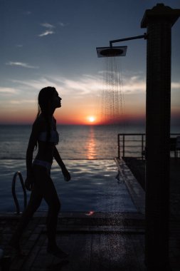 havuz ve deniz gün batımında duş mükemmel bir şekilde güzel bir kızla silüeti