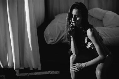 Bikini modeli. Güzel seksi esmer kız modeli uzun dalgalı saçlı, güneş yanığı sahilde moda mayo giyiyor. Tatil. Yanık tenli kadın.