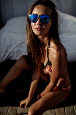 Güzel kız esmer mayo, seksi model, mükemmel rakam, güneş ışığı mavi güneş gözlüğü