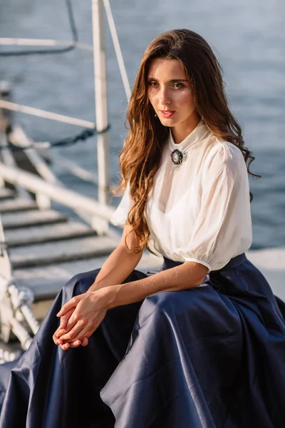 由海附近的游艇，船在蓝色长裙走在码头上的漂亮女孩 — 图库照片
