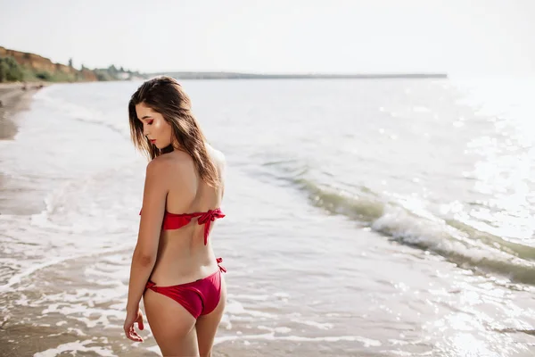 Menina sexy de aparência asiática em seu maiô no mar com areia, moda — Fotografia de Stock