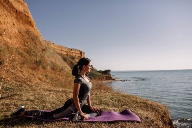 güzel kız ile spor formları spor sahilde, içme suyu, atlama, çalıştırma, farklı egzersizleri yapıyor