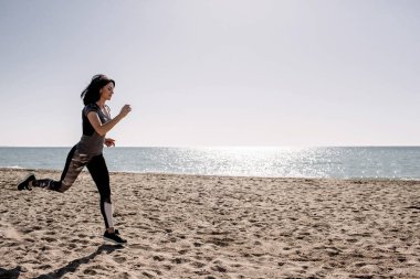 güzel kız ile spor formları spor sahilde, içme suyu, atlama, çalıştırma, farklı egzersizleri yapıyor