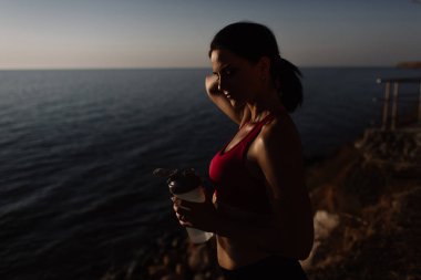 güzel kız ile spor formları spor sahilde, içme suyu, atlama, çalıştırma, farklı egzersizleri yapıyor