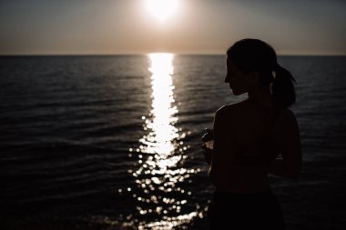 güzel kız ile spor formları spor sahilde, içme suyu, atlama, çalıştırma, farklı egzersizleri yapıyor