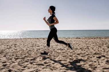 güzel kız ile spor formları spor sahilde, içme suyu, atlama, çalıştırma, farklı egzersizleri yapıyor