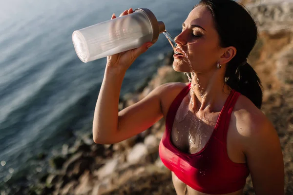 güzel kız ile spor formları spor sahilde, içme suyu, atlama, çalıştırma, farklı egzersizleri yapıyor