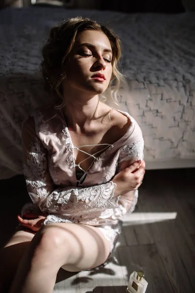 란제리 오래 다리 섹시 포즈 큰 창, 꽃과 그녀의 침실 침대에 기대어 보여주는 아름 다운 여자. 성적인 추억입니다. 신부 내실입니다. 결혼식 아침. — 스톡 사진