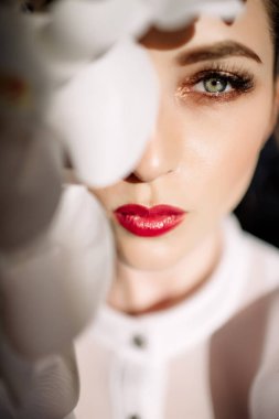 Güzel sarışın kız tutan orkide, sert güneş ışığı, moda