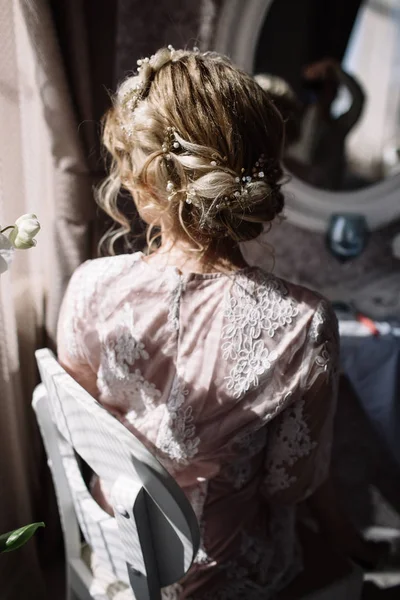 Bride's morning. Fine art wedding. Portrait of a young bride in white lace boudoir with wavy blonde hair and a bouquet in her hands posing looking down shyly — Stock Photo, Image