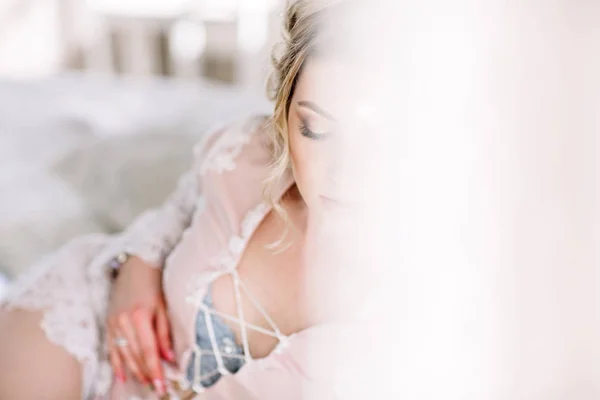 La novia en un albornoz a la ventana del dormitorio por la mañana —  Fotos de Stock