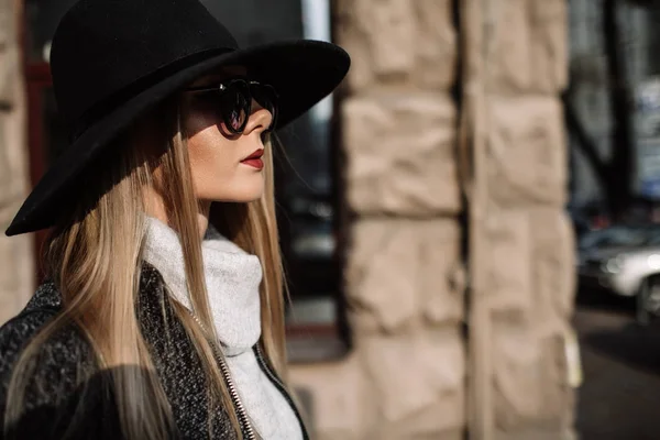 Primo piano ritratto di una giovane bella donna alla moda che indossa occhiali da sole. Un modello in un elegante cappello a tesa larga . — Foto Stock