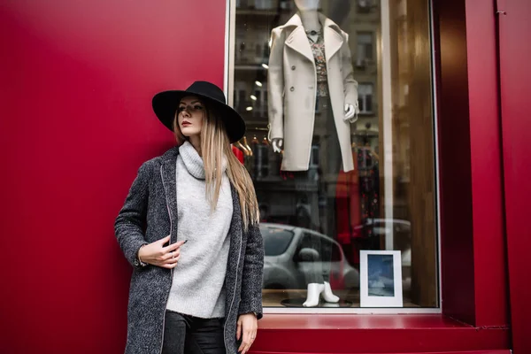 Primo piano ritratto di una giovane bella donna alla moda che indossa occhiali da sole. Un modello in un elegante cappello a tesa larga su sfondo blu. Vestiti armoniosamente simili nei toni del grigio. Stile di Uleach di — Foto Stock