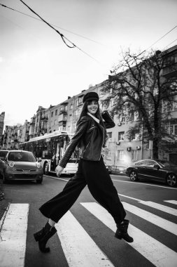 Güneş gözlüğü güzel kızla. Şapkalı şık geniş ekledi bir yaya geçidi adlı bir model. Gri tonları uyum benzer giysilerle. Sokak tarzı çekim. Kadın moda.