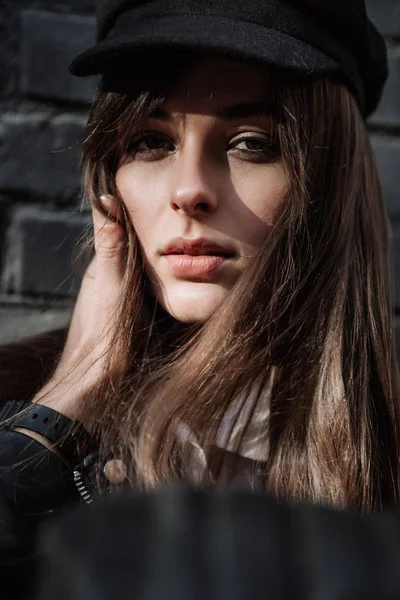 Retrato de una hermosa modelo de moda en una gorra. Los brazos de los hombres abrazan la cara — Foto de Stock