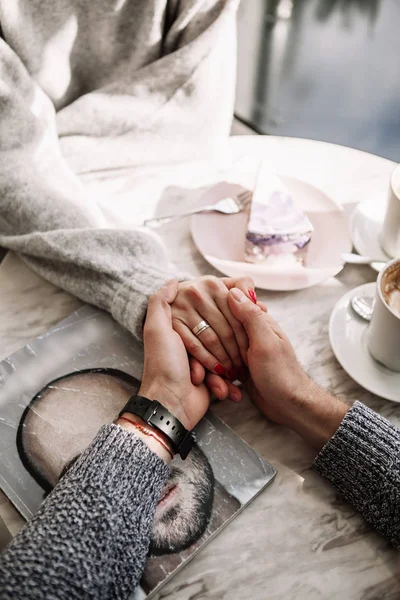 Мужские и женские руки с чашками кофе на фоне деревянного стола — стоковое фото