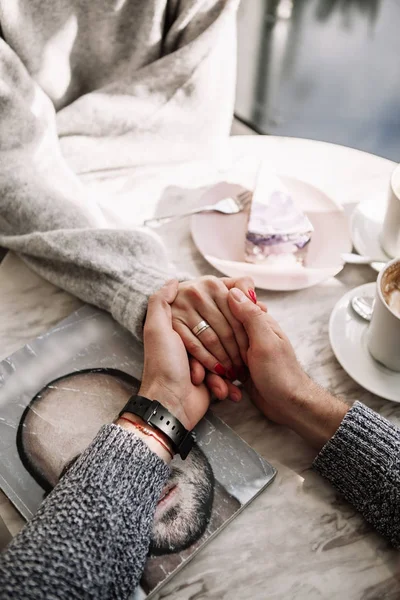 Female and man hands with cups of coffee on the background of a wooden table — Stock Photo, Image