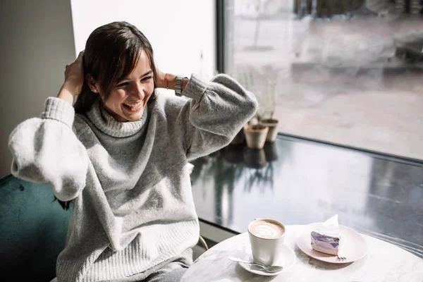 Beautiful girl laughs drinks coffee, tea — Stock Photo, Image