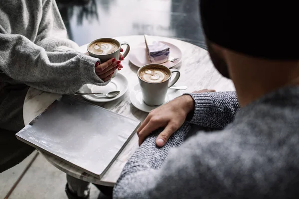 Frauen- und Männerhände mit Kaffeebechern auf dem Hintergrund eines Holztisches — Stockfoto