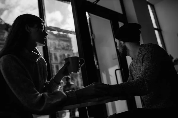 Dos jóvenes alegres amantes que bebían café en las cafeterías — Foto de Stock