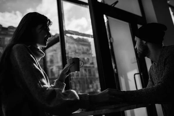 Dos jóvenes alegres amantes que bebían café en las cafeterías — Foto de Stock