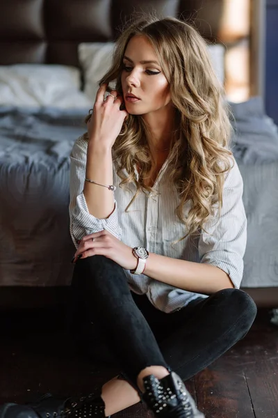 Девушка с длинными светлыми волосами, одетая в черные джинсы, полосатая девка — стоковое фото