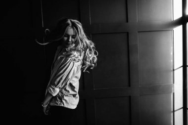 Genç güzel kadın model beyaz bir gömlek, siyah kot, kendine güvenen, mavi arka plan