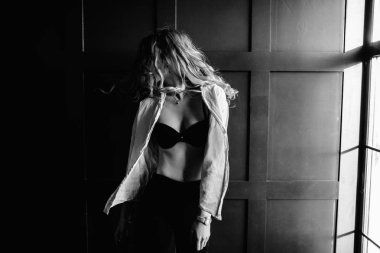 Genç güzel kadın model beyaz bir gömlek, siyah kot, kendine güvenen, mavi arka plan