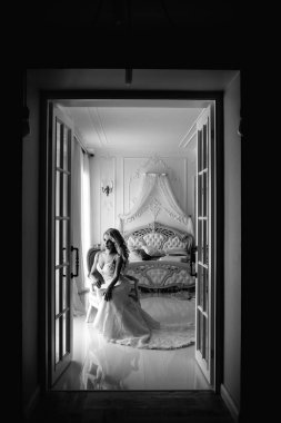 Düğün. Kapalı beyaz bir stüdyoda, güzel bir elbise içinde gelin evde severim. Şık düğün tarzı tam uzunlukta alınır. Bir gelin gibi kıvırcık saçlı genç çekici sarışın model