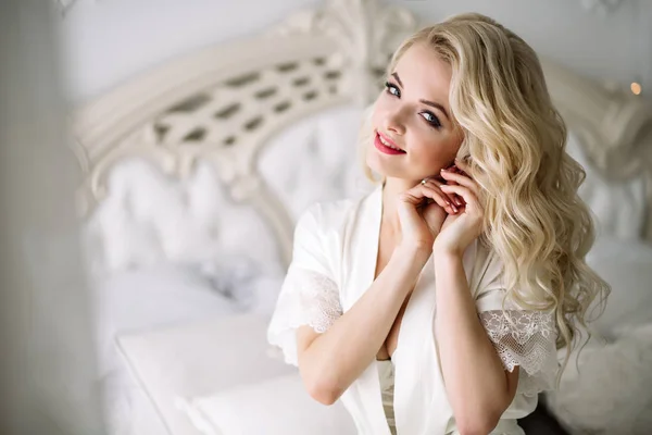 Портрет блондинки невесты, сидящей на королевской кровати. Естественное освещение — стоковое фото