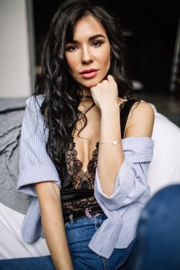 Mavi jeans ve mavi gömlek, moda katta oturan sevimli genç kadın