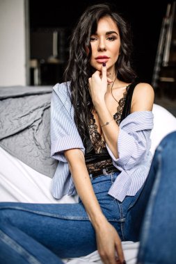 Mavi jeans ve mavi gömlek, moda katta oturan sevimli genç kadın