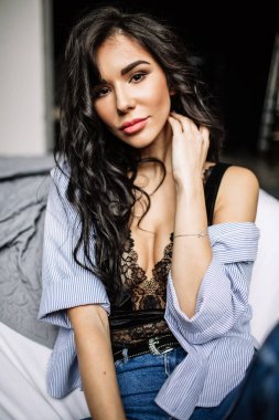 Mavi jeans ve mavi gömlek, moda katta oturan sevimli genç kadın