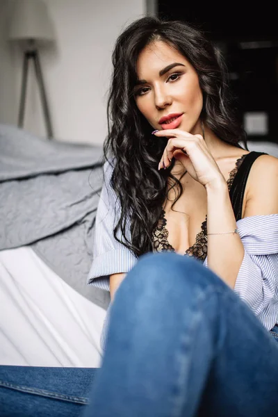 Giovane donna carina seduta sul pavimento in jeans blu e camicia blu, moda — Foto Stock