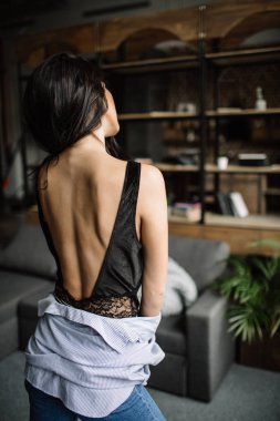 Ön plan. Güzel esmer bir kitaplık ve Li, moda stil arka arka planda bir odada mavi tişört ve kot pantolon giymiş