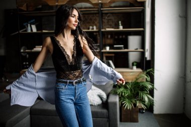 Ön plan. Güzel esmer bir kitaplık ve Li, moda stil arka arka planda bir odada mavi tişört ve kot pantolon giymiş