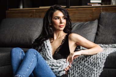 Mavi jeans ve mavi gömlek, moda katta oturan sevimli genç kadın