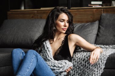 Mavi jeans ve mavi gömlek, moda katta oturan sevimli genç kadın