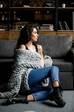 Mavi jeans ve mavi gömlek, moda katta oturan sevimli genç kadın