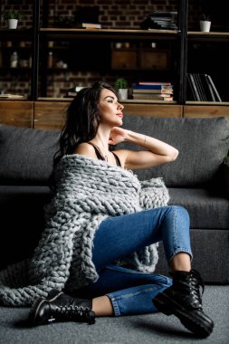 Mavi jeans ve mavi gömlek, moda katta oturan sevimli genç kadın
