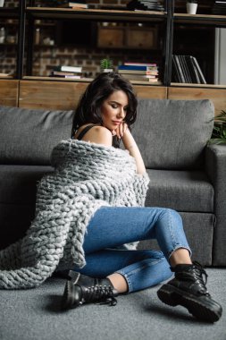 Mavi jeans ve mavi gömlek, moda katta oturan sevimli genç kadın