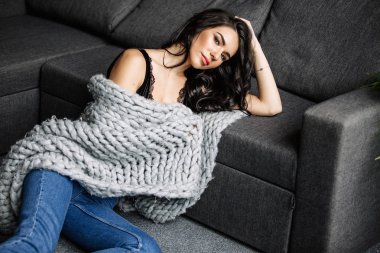 Mavi jeans ve mavi gömlek, moda katta oturan sevimli genç kadın