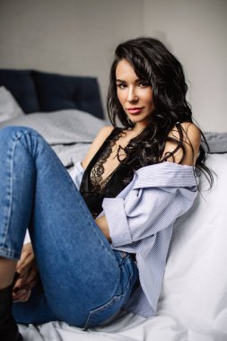 Mavi jeans ve mavi gömlek, moda katta oturan sevimli genç kadın