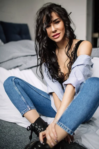 Mignonne jeune femme assise sur le sol en jeans bleus et chemise bleue, mode — Photo