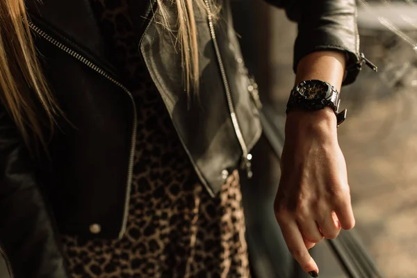 Reloj negro con flechas doradas en la mano de una mujer. Relojes de moda en un estilo moderno — Foto de Stock