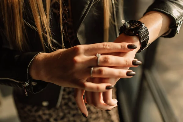 Fekete óra arany nyilakkal egy nő kezén. Divatórák modern stílusban — Stock Fotó