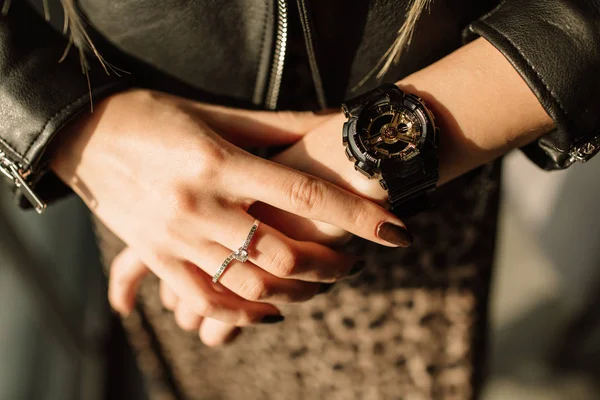 Reloj negro con flechas doradas en la mano de una mujer. Relojes de moda en un estilo moderno — Foto de Stock