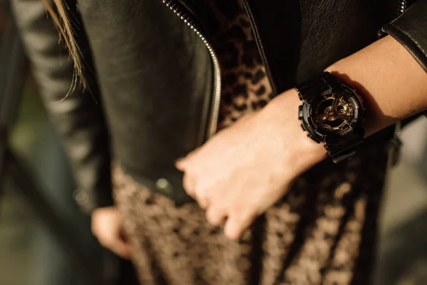 Reloj negro con flechas doradas en la mano de una mujer. Relojes de moda en un estilo moderno — Foto de Stock