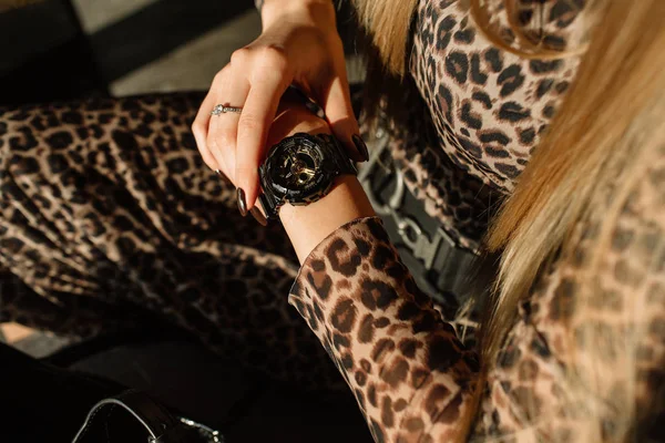 Reloj negro con flechas doradas en la mano de una mujer. Relojes de moda en un estilo moderno — Foto de Stock