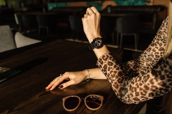 Black watch with golden arrows on a woman's hand. Fashion watches in a modern style — Stock Photo, Image